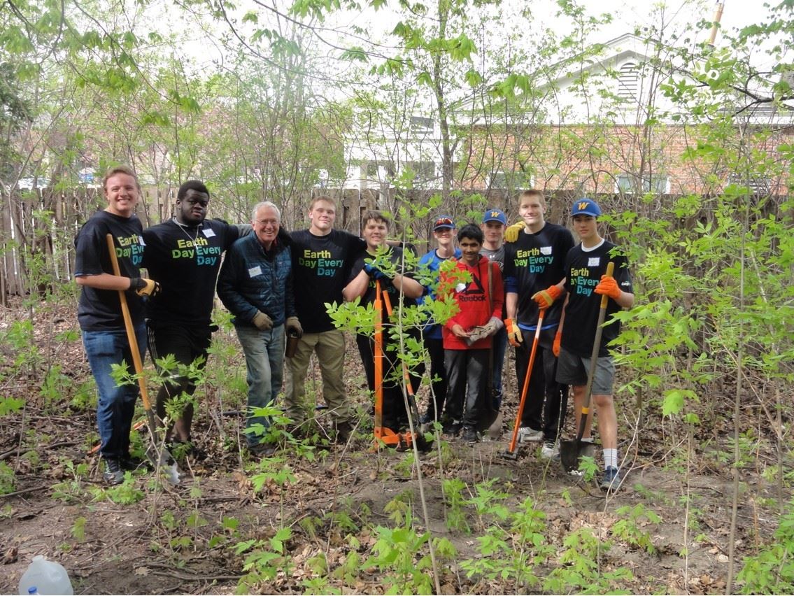 Part of the Wayzata High School football team pausing during buckthorn removal